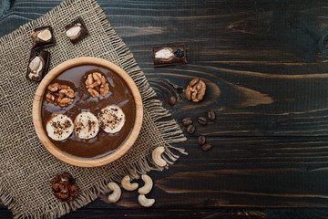 Homemade chocolate banana  smoothie on a bowl  on wooden  background, flat lay