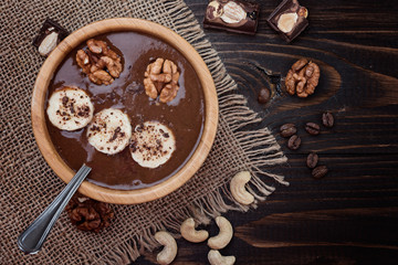 Homemade chocolate banana  smoothie on a bowl  on wooden  background, flat lay