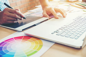 Graphic designer drawing on graphics tablet at workplace
