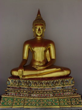 Golden seated Buddha on pedestal 