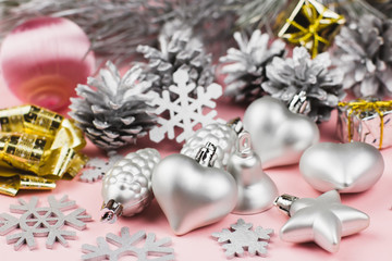 Silver Christmas ornaments close up on a pastel pink background
