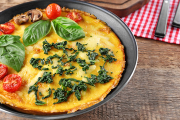Tasty frittata with spinach on table
