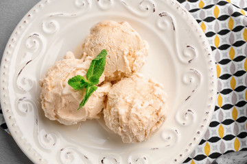 Plate with caramel ice cream on table, closeup