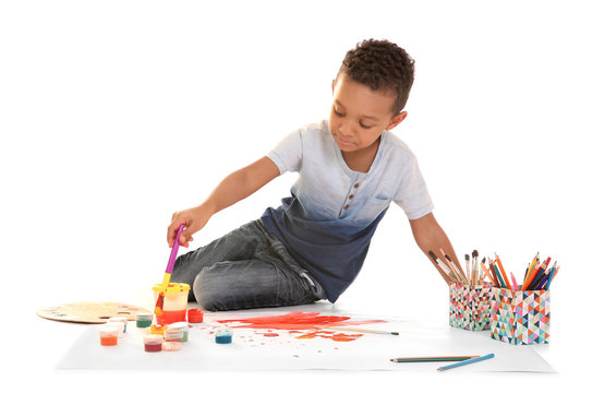 Little African-American boy painting against white background