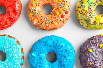 Tasty colorful donuts on white background