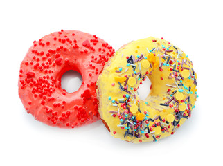 Colorful donuts with sprinkles on white background