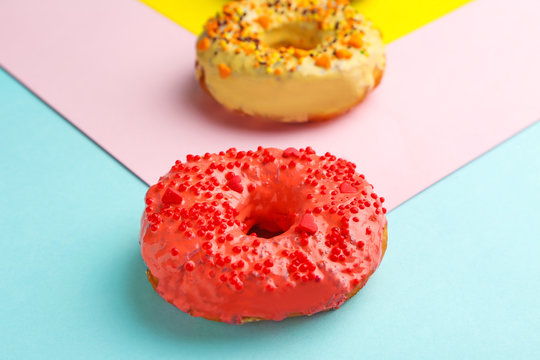 Delicious red donut on color background