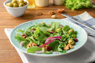 Plate with delicious vegetable salad on table