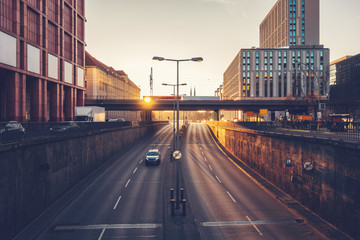 Cars driving on a city highway at sunrise