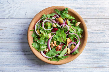Bowl with delicious vegetable salad on light wooden background