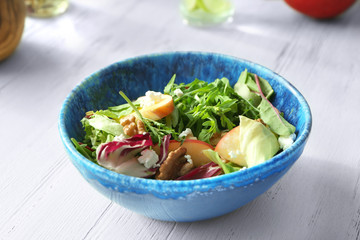 Bowl with delicious vegetable salad on light background