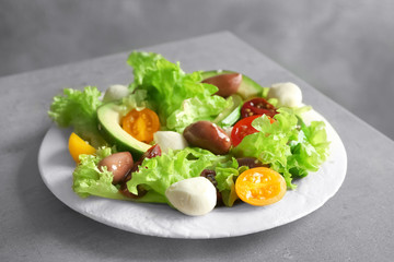 Plate with delicious vegetable salad on table