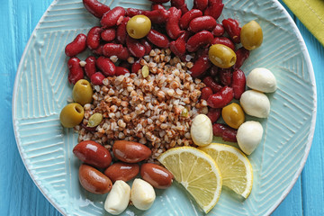 Plate with buckwheat porridge, beans and mozzarella on table, closeup