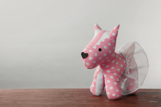 Cute toy dog on table against light background