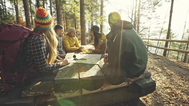 Hikers planning route at table in woods