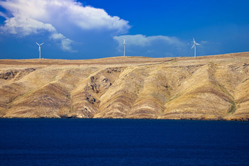 Stone desert island of Pag wind power plants view