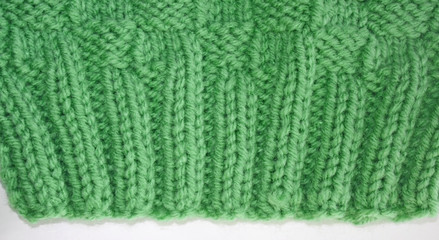 Close up of the knitted Rib Stitch.  Knit two, purl two, knit two, purl two in a pretty green color wool.  Then knitted in a Basket Weave stitch
