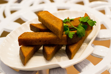 Snack of croutons from black bread with greens