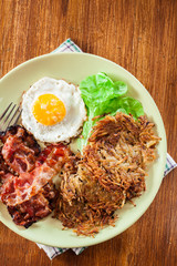 Hash browns. Potato pancakes with crispy fried bacon and fried e