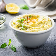 Healthy clean eating snack, hummus in a bowl on stone or concrete background. 