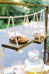 raw foodism, handmade, benefit concept. handcrafted flying wooden shelves strengthened with help of tough twines, they holding plates with dried fruits and nuts