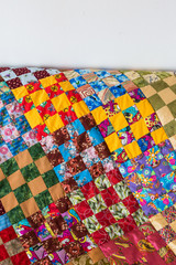 retro, fashion, housekeeping concept. bedcover made in quilt style gently stiched from different peaces of textile has yellow, blue, green color zones