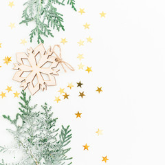 Christmas composition made of fir branches, decoration with golden confetti on white background. Flat lay, top view