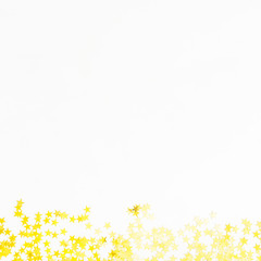 Golden confetti isolated on white background. Flat lay, top view. Copy space