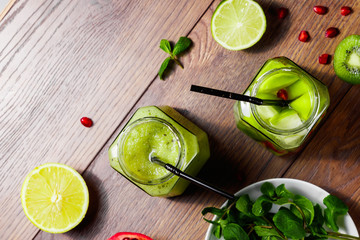 Green cocktail in a glass jar of kiwi, green apple, lime, mint and granate. The concept of a healthy diet, detox. A refreshing drink. View from above.