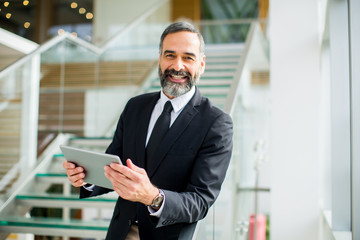 Middle age businessman with tablet in the office