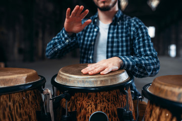 Drummer hands playing on wooden drum, closeup