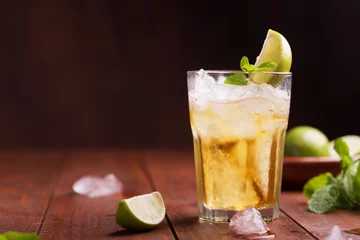 Foto auf Acrylglas Frischer Cocktail zubereitet mit Ginger Beer, Limette und Eis © zakiroff