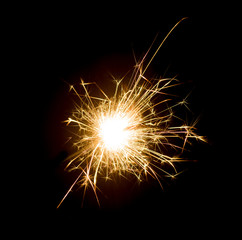 Bright sparks on deep black background closeup. Party holiday sparkler isolated on black