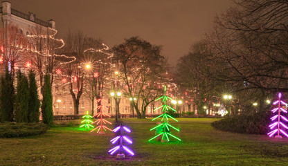 Night christmas background, christmas city illumination. Christmas neon tree in downtown. Riga, Latvia.