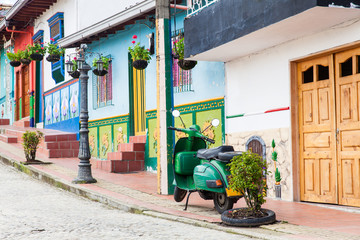 Fototapeta premium Green motorcycle at the colorful town of Guatape, Antioquia – Colombia.