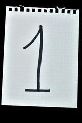 the numbers drawn on a piece of paper on a black background. isolated