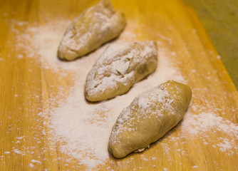 formation of cakes with fillings. raw before staging in the oven on a wooden background