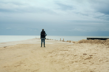 A lone explorer discovering an amazing pier by the sea, in the middle of nowhere.
