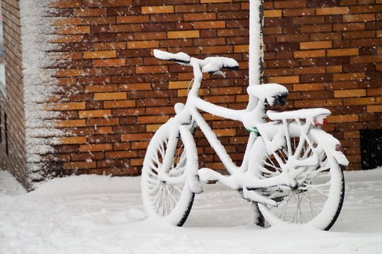 Verschneites Fahrrad an einer Ecke