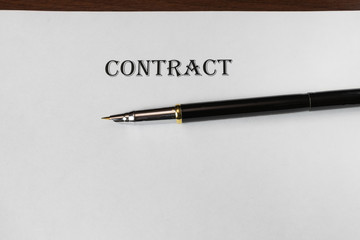 Pen and contract papers on wooden desk