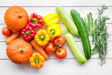 Base of healthy diet. Vegetables pumpkin, paprika, tomatoes, carrot, zucchini on white wooden background top view