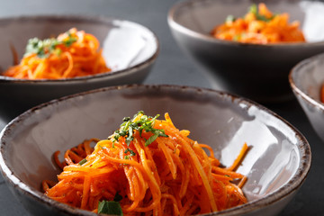 Set of plates with russian korean salad, closeup