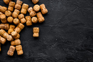 Heap of wine bottle corks on black background top view copyspace