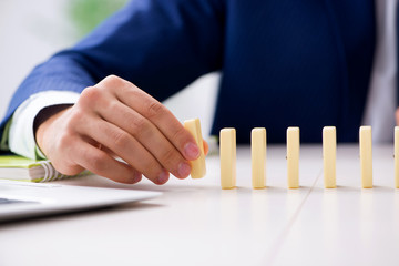 Young businessman playing with domino in office