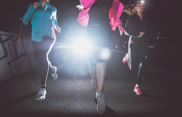 Three women running in the night in the city center