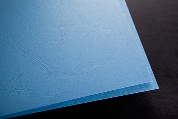 Curled corner of blue paper. Mock up. Close up. Macro shot.