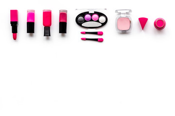 Makeup set pattern. Eyeshadows, rouge, nailpolish, lipstick, applicators on white background top view copyspace