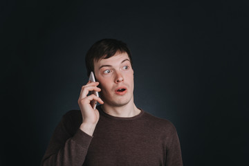 Man talking on the phone heard the shocking news, closeup portrait