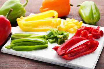 Sliced peppers on white wooden cutting board