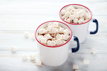 Cappuccino with marshmallow in mugs on wooden table